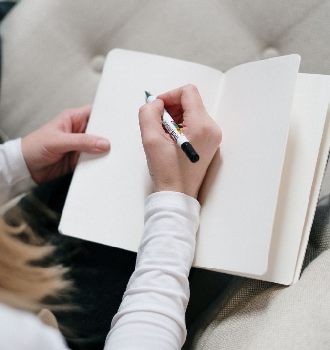 Woman taking notes during her online English lessons